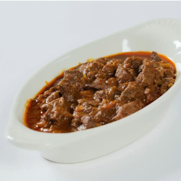 Messob Ethiopian Restaurant's flavorful beef tibs, a rich stew with tender meat in a white serving dish.