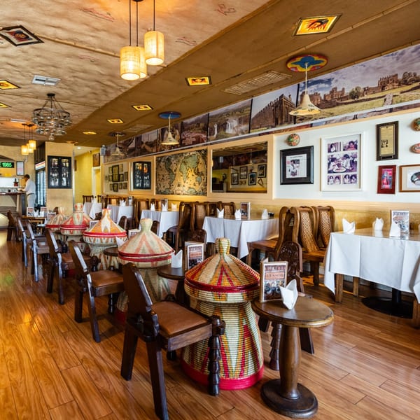 Messob Ethiopian Restaurant's dining room with traditional woven baskets, wooden chairs, and cultural decor.